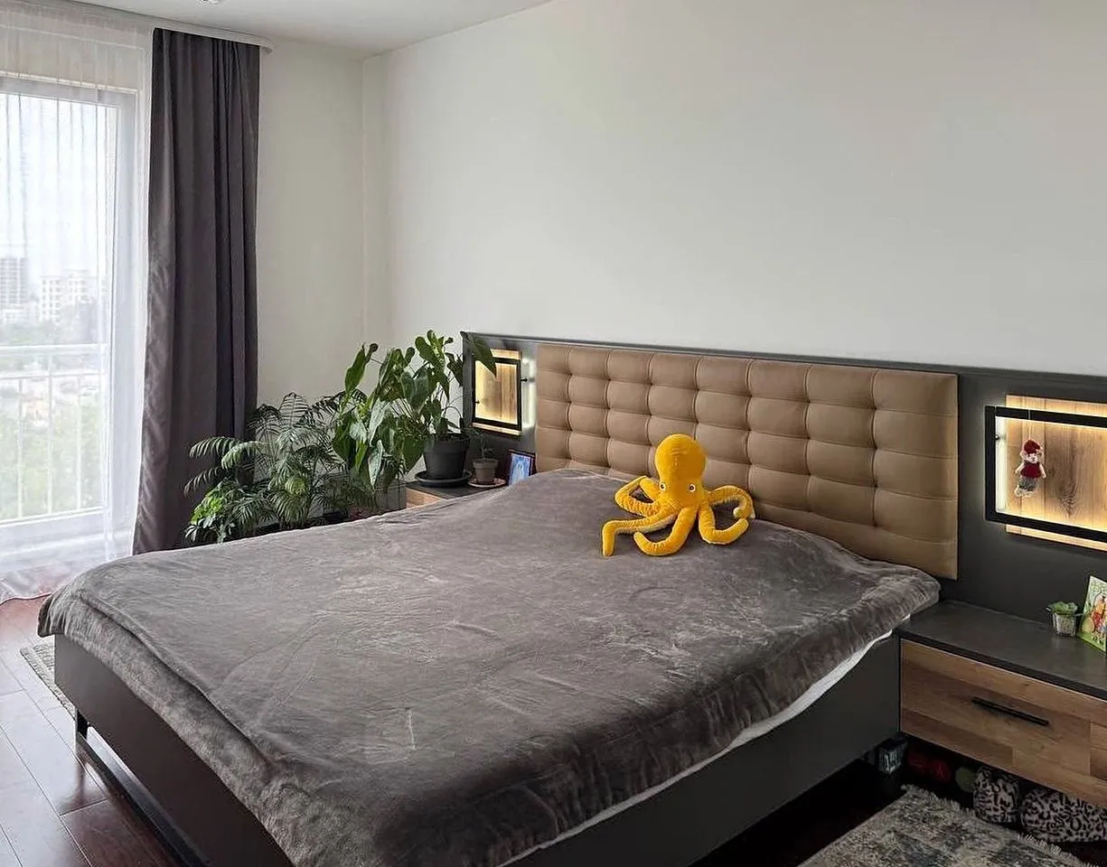 Furnished bedroom with a double bed, headboard, and bedside tables.