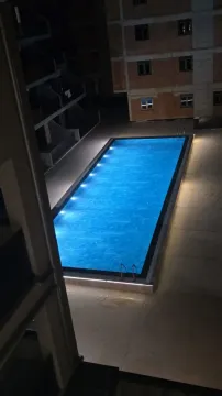 Noćni pogled odozgo na osvijetljeni bazen ispred stambene zgrade. - image 15
