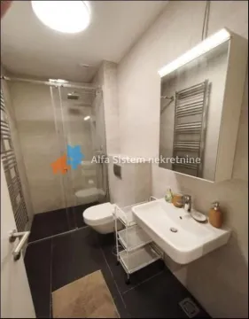 Modern bathroom with a shower cabin, washbasin, and toilet. - image 14