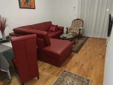 Bright living room with a red leather sofa set and wooden flooring. - image 12