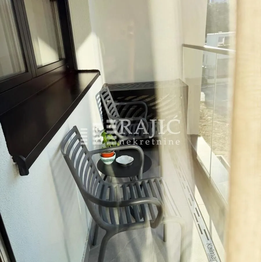 Small furnished balcony with a small table and chairs.
