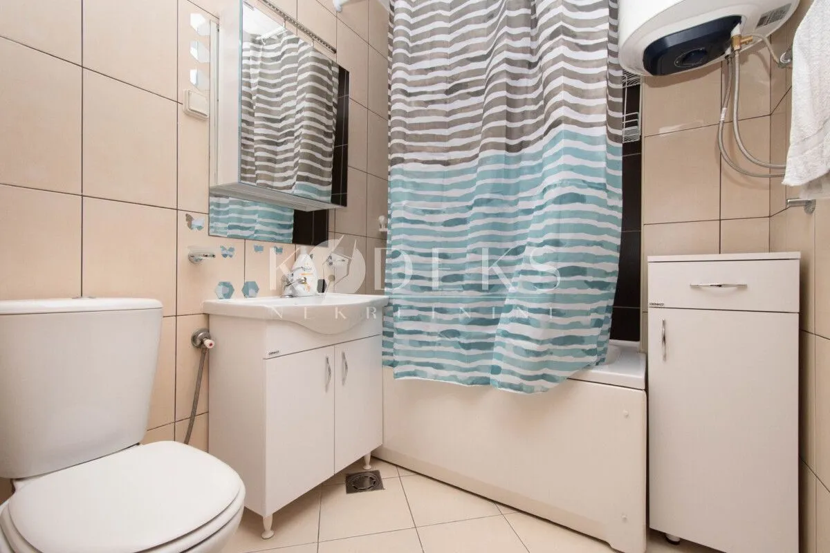 Manje kupatilo sa tuš kadom, umivaonikom i wc šoljom.