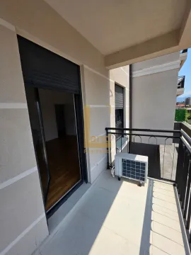 Manji natkriveni balkon sa spoljnom jedinicom klima uređaja i pogledom na okolinu. - image 5