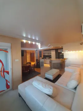Spacious living room with a sofa set and a view of the kitchen and dining area. - image 3