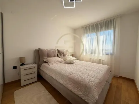Spavaća soba sa bračnim krevetom, noćnim ormarićem i prozorom sa zavesama. - image 15