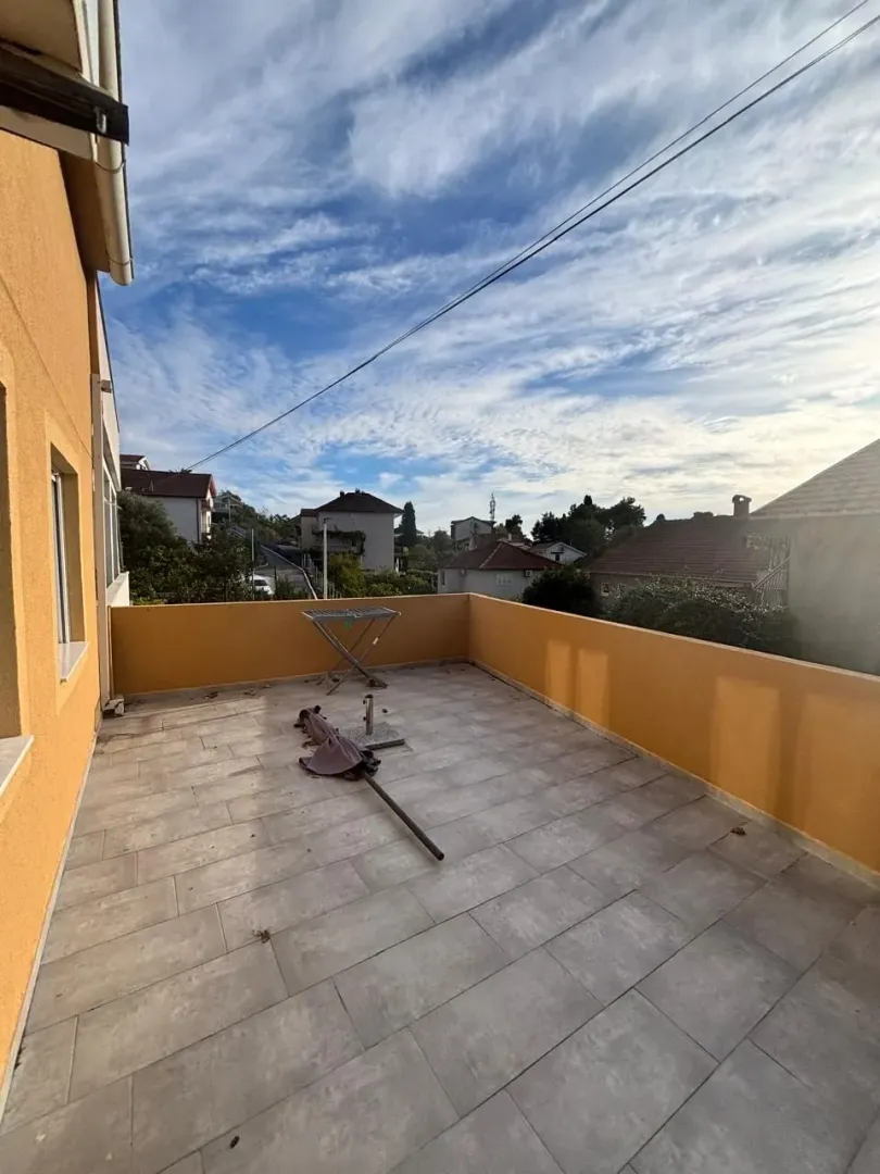 Spacious unfurnished terrace with a view of the surrounding neighborhood and sky.
