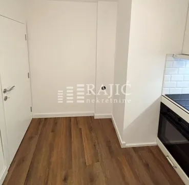 View of a section of the kitchen with built-in appliances and hardwood flooring. - image 8