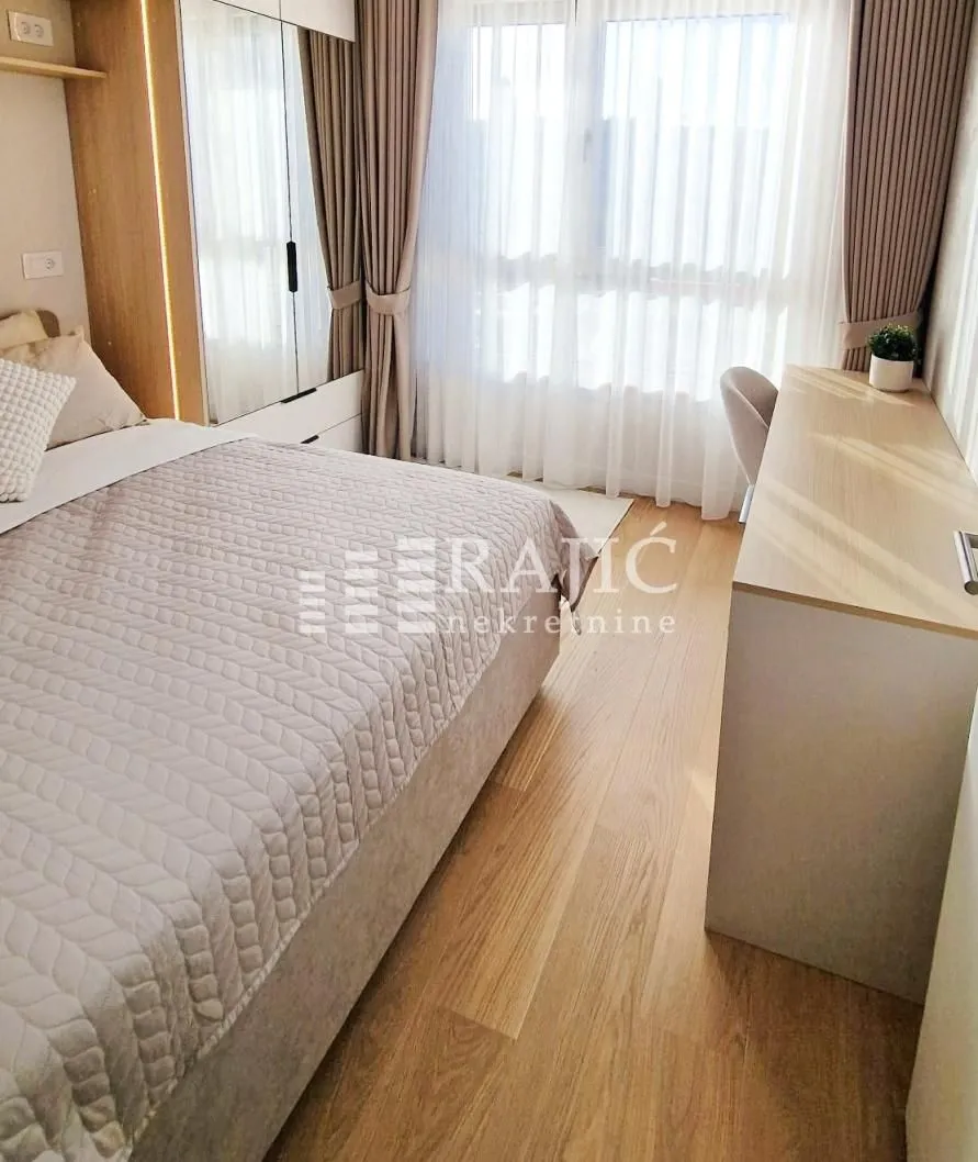 Modern bedroom with a double bed, wardrobe, and desk.