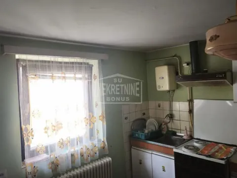 Starija kuhinja sa sudoperom, šporetom i prozorom. - image 3