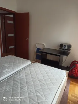 Jednostavna spavaća soba sa dva singl dušeka i malim stolom. - image 3