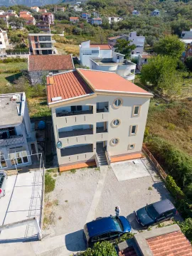 Aerial view of a multi-family house with a yard and parked cars. - image 10