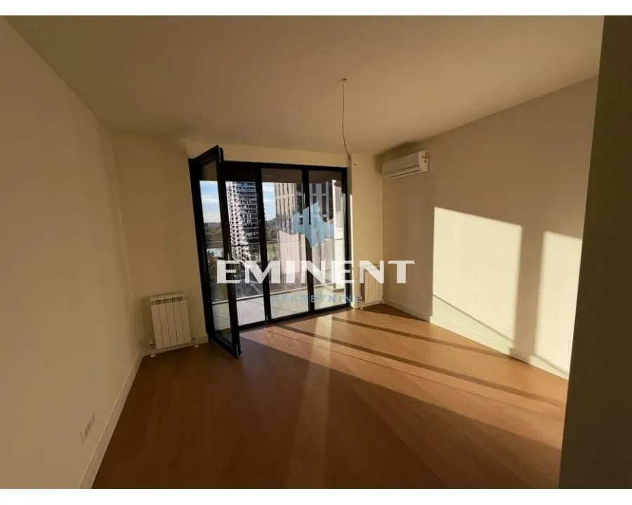 Empty room with wooden flooring and access to the terrace.