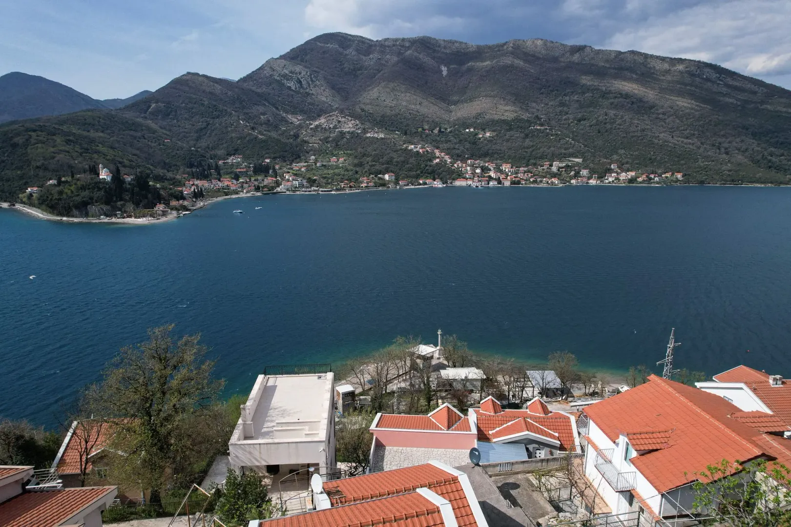 Pogled na zaliv i okolne objekte sa terase ili prozora.
