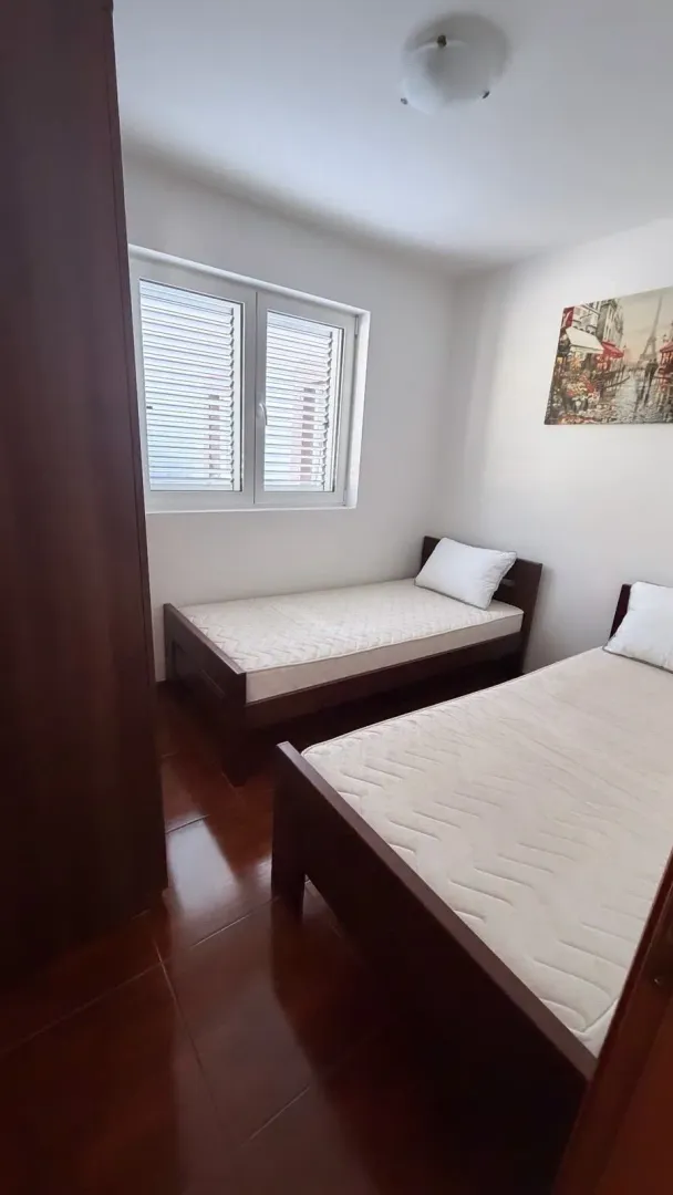 Spavaća soba sa dva kreveta za jednu osobu i prozorom.