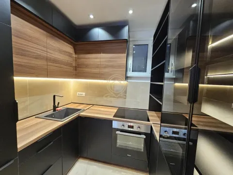 Modern kitchen with dark cabinets and wood-grain countertops. - image 12