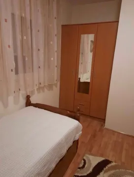 Furnished bedroom with a bed, wardrobe, and window. - image 5