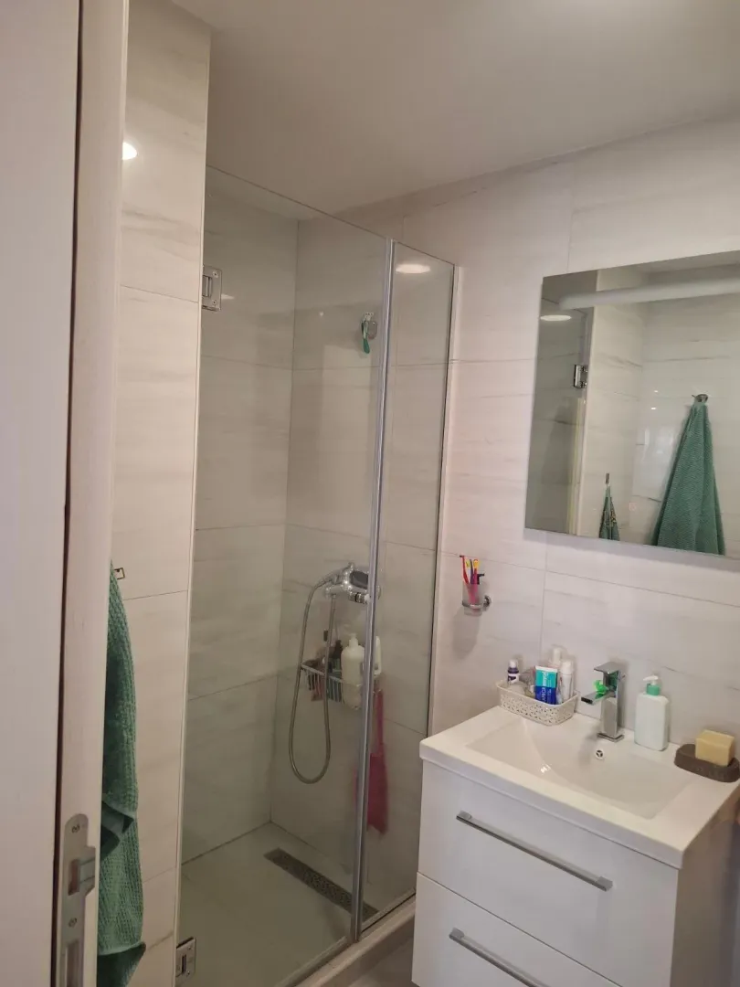 Bright modern bathroom with a shower cabin and a washbasin.