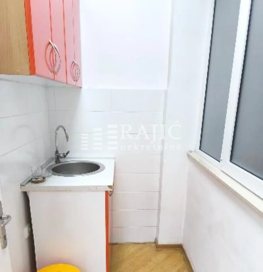 Small kitchen with a sink, cabinets, and a window.