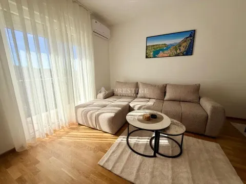 Living room with a sectional sofa, coffee table, and large window. - image 3