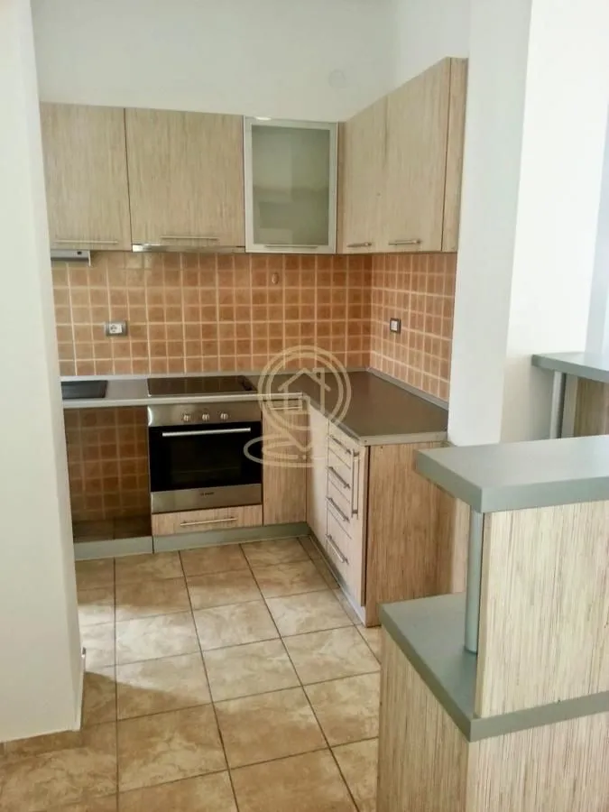Kitchen with wooden cabinetry and ceramic tiles.
