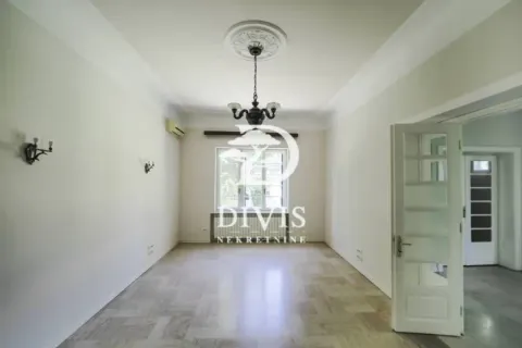 Empty spacious room with parquet flooring, a chandelier, and doors leading to another room. - image 2
