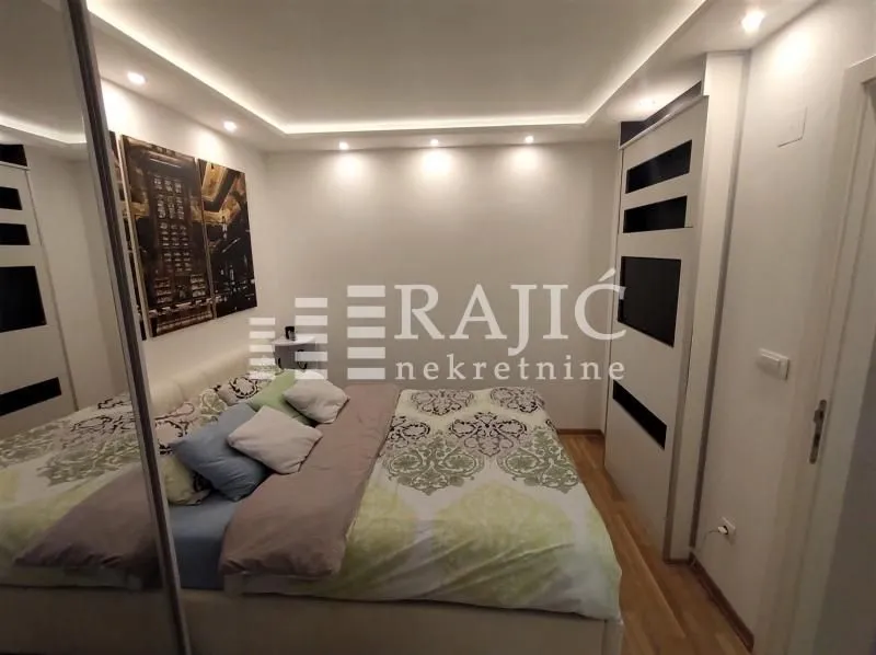 Furnished bedroom with a double bed and built-in wardrobes.