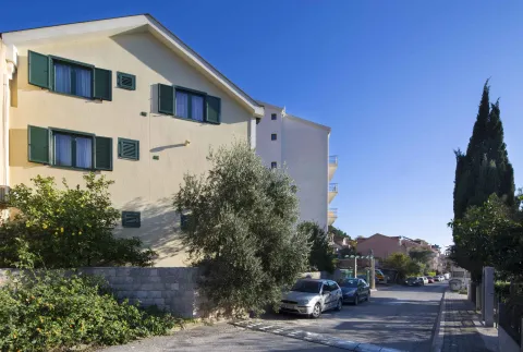 Pogled na spoljašnjost zgrade sa zelenilom i ulicom. - image 8