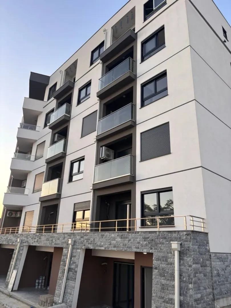 Spoljašnji izgled moderne stambene zgrade sa balkonom.