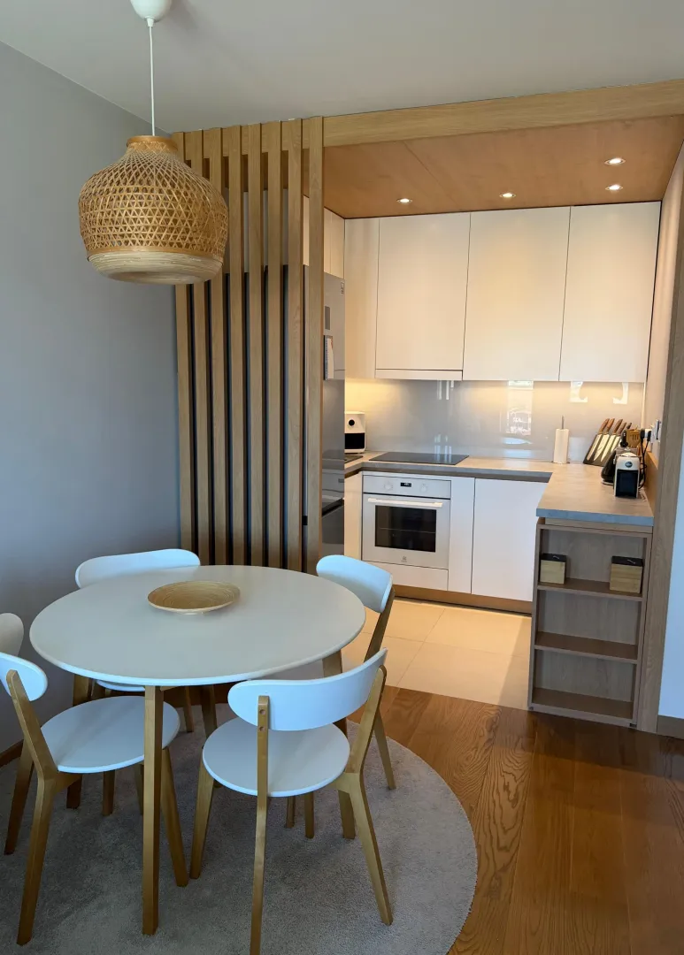 Modern kitchen with a dining area and white cabinets.