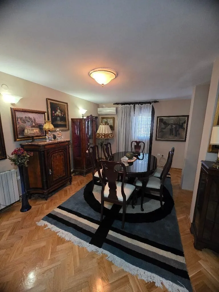 Living room with a dining table, classic furniture, and paintings on the wall.