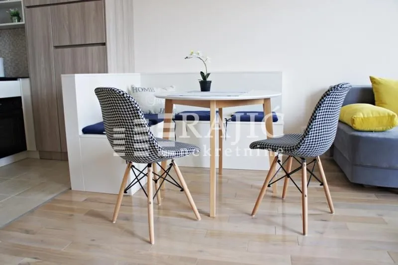 Dining nook with a table and modern chairs within the living room.