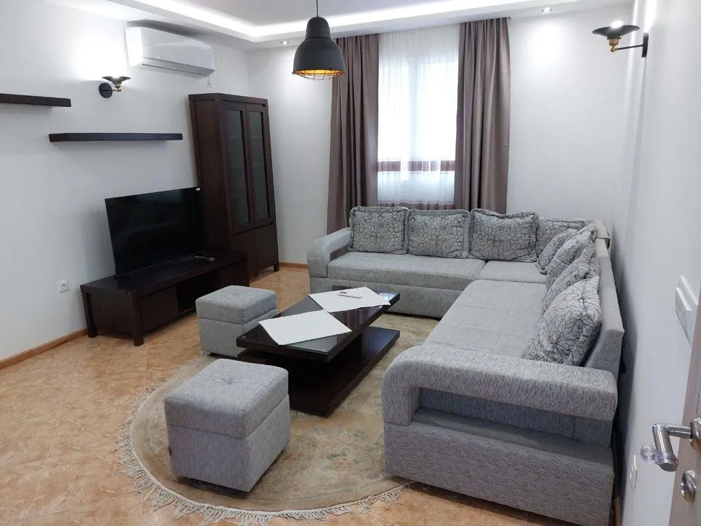 Living room with a corner sofa, TV, and coffee table.
