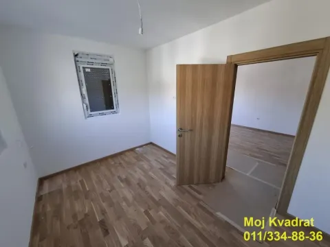 Prazna prostorija sa parketom i otvorenim vratima prema drugoj sobi. - image 6