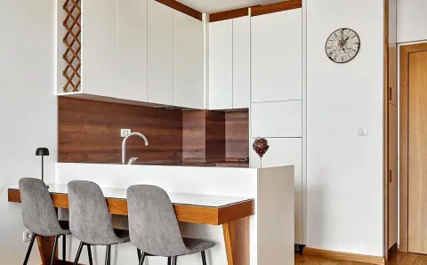 Modern kitchen with white cabinetry and a breakfast bar. - image 4
