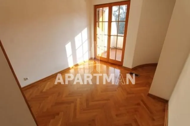 Empty room with hardwood flooring and balcony doors.