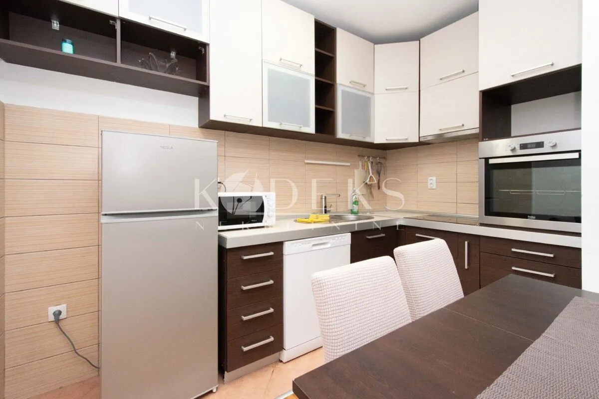 Kitchen equipped with household appliances and a dining table.