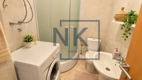 Compact bathroom with a shower cabin, washbasin, toilet, and washing machine. - image 7