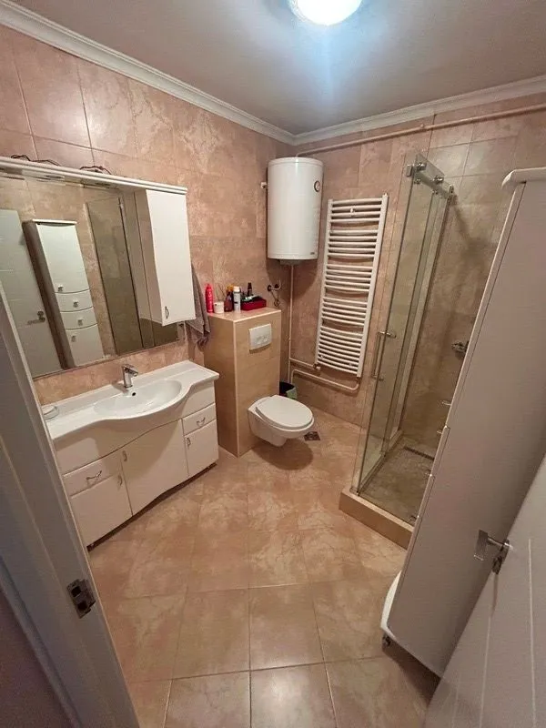 Kupatilo opremljeno umivaonikom, WC šoljom, tuš kabinom i bojlerom.