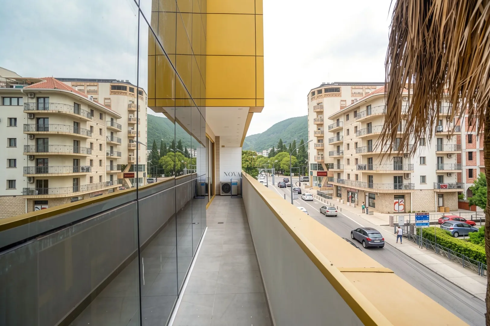 Long tiled balcony with a view of the street and surrounding buildings.