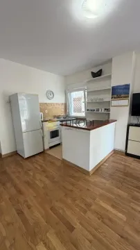 Small kitchen with a breakfast bar, refrigerator, and wooden floor. - image 8