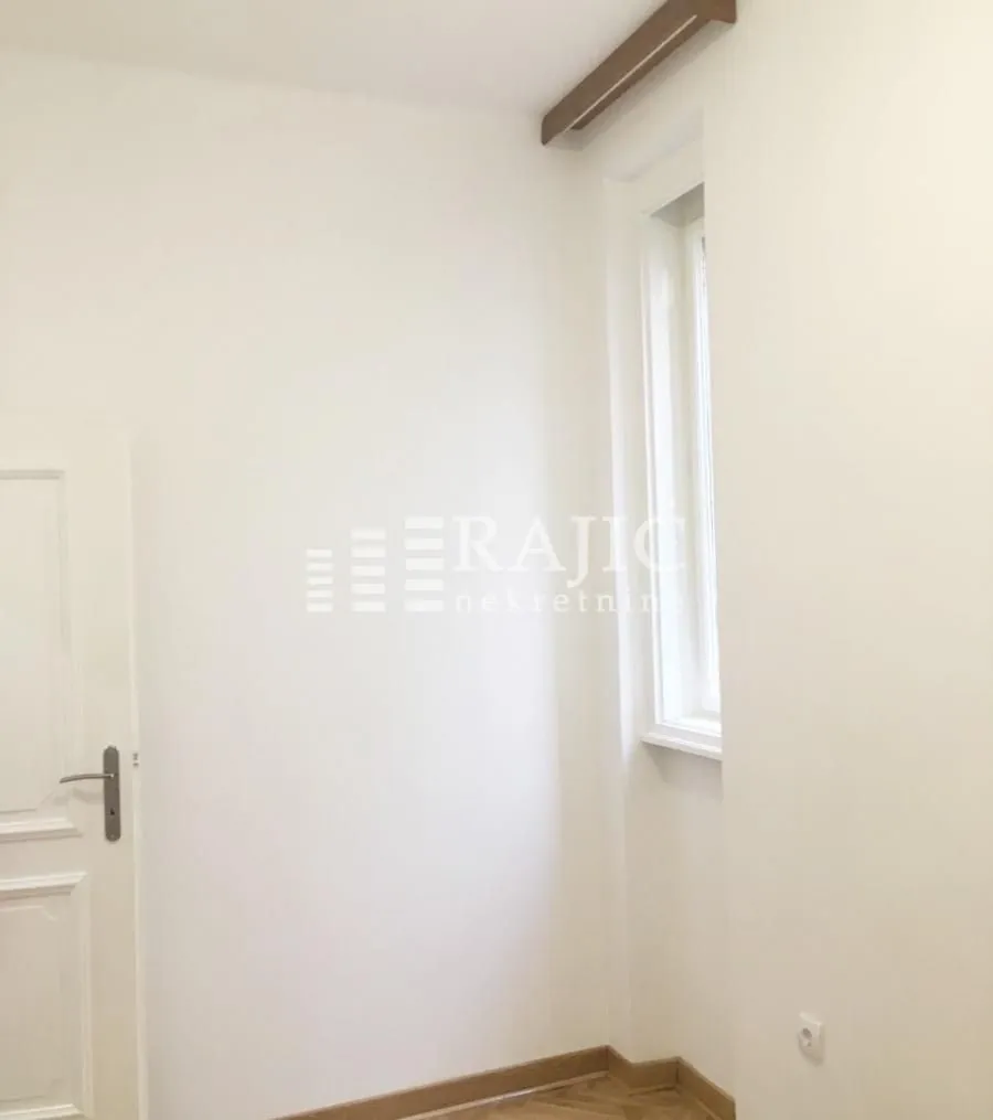 Empty bright room with white walls and a window.