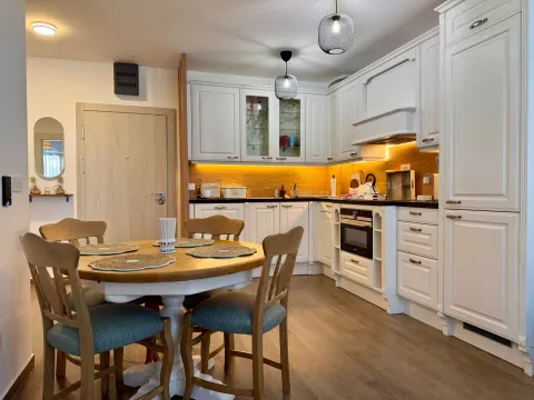 Kitchen with dining area and white cabinetry. - image 4