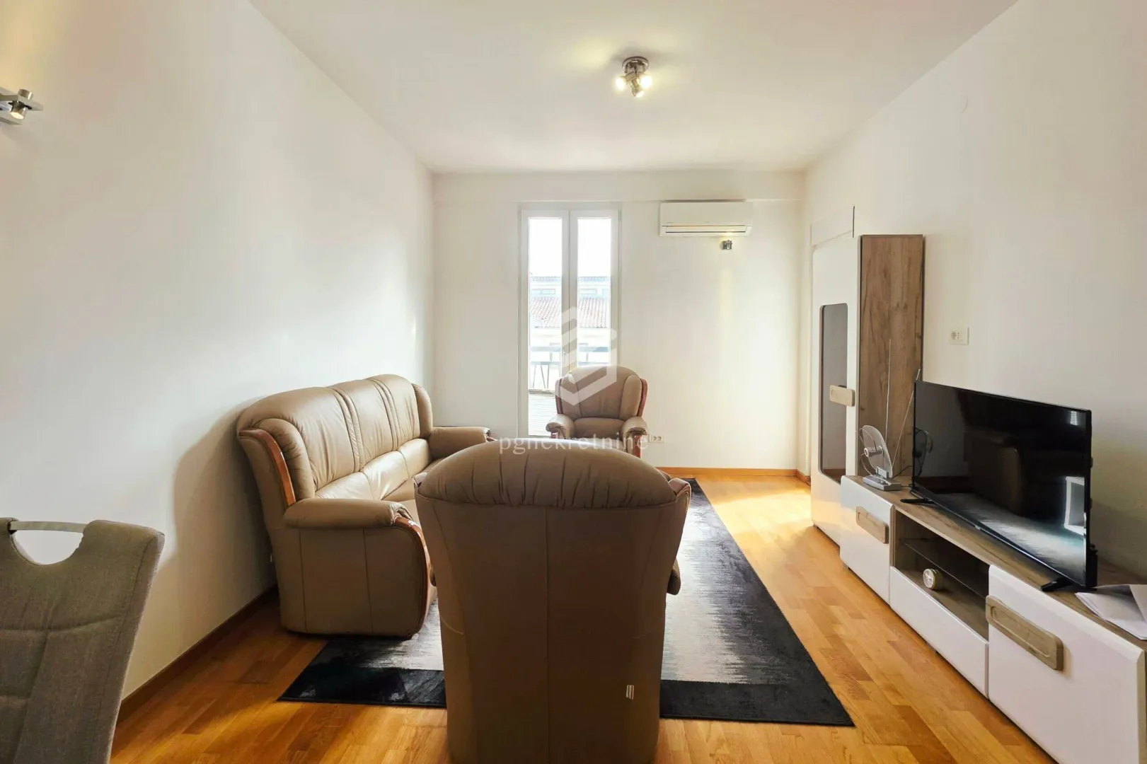 Living room with sofa set, TV, and access to the terrace.