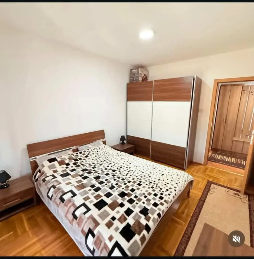 Furnished bedroom with a double bed, wardrobe, and parquet flooring.