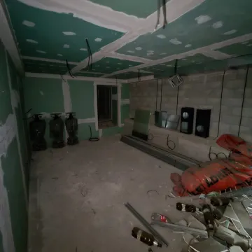 An unfinished room under renovation with drywall and construction materials. - image 9