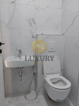 Small bathroom with white marble tiles, sink, and toilet. - image 7