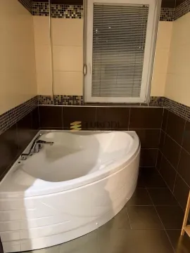 Kupatilo sa ugaonom kadom i keramičkim pločicama u braon tonovima. - image 3