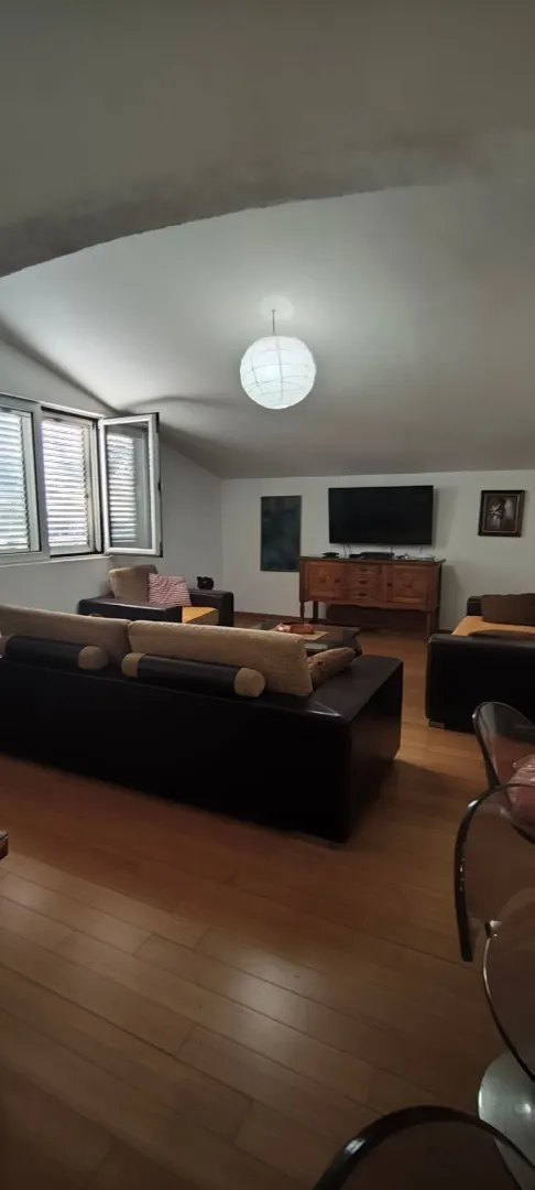 Spacious living room with sofa set and TV.