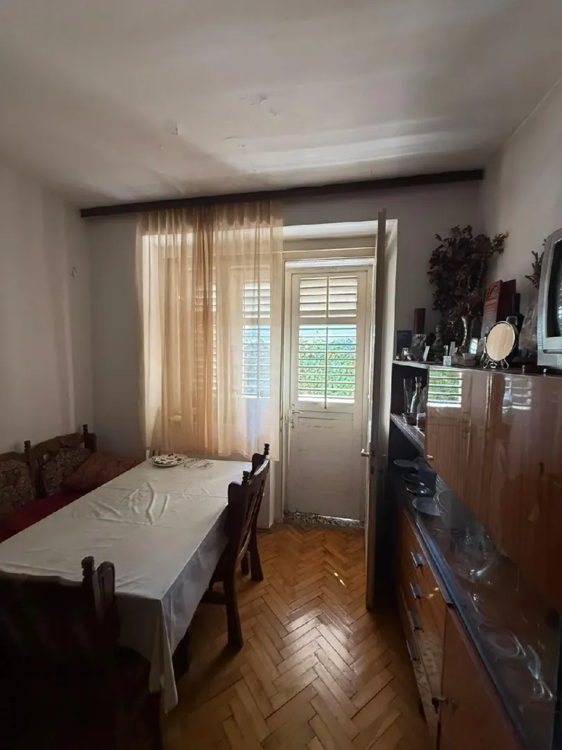 Trpezarija sa drvenim stolom, stolicama i namještajem.