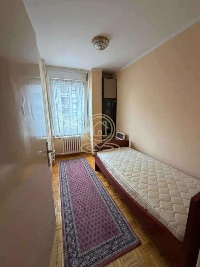 Manja spavaća soba sa krevetom i prozorom.